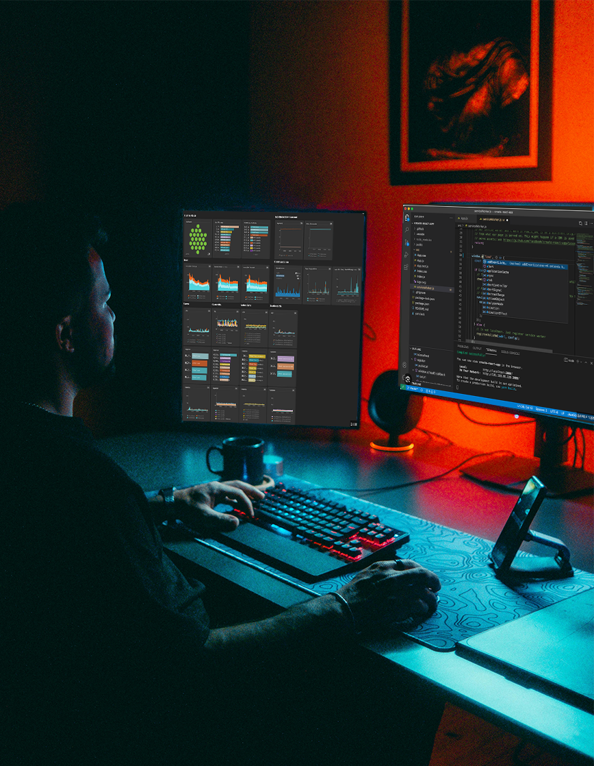 IT support engineer working late at night in front of multiple system monitoring screens, ensuring continuous application performance and reliability.